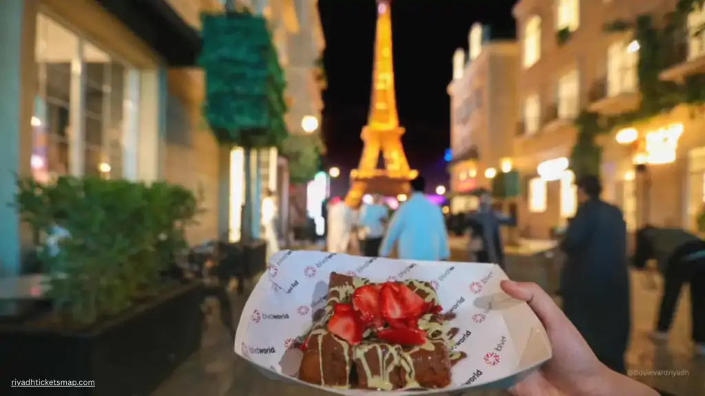 Ramadan at Boulevard Riyadh City 2026: A Complete Guide 7 Strawberry chocolate dessert held in front of the Eiffel Tower replica at Boulevard Riyadh City Paris Zone during Riyadh Season night event